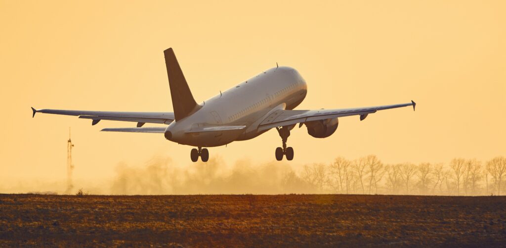 Airplane taking off at sunset